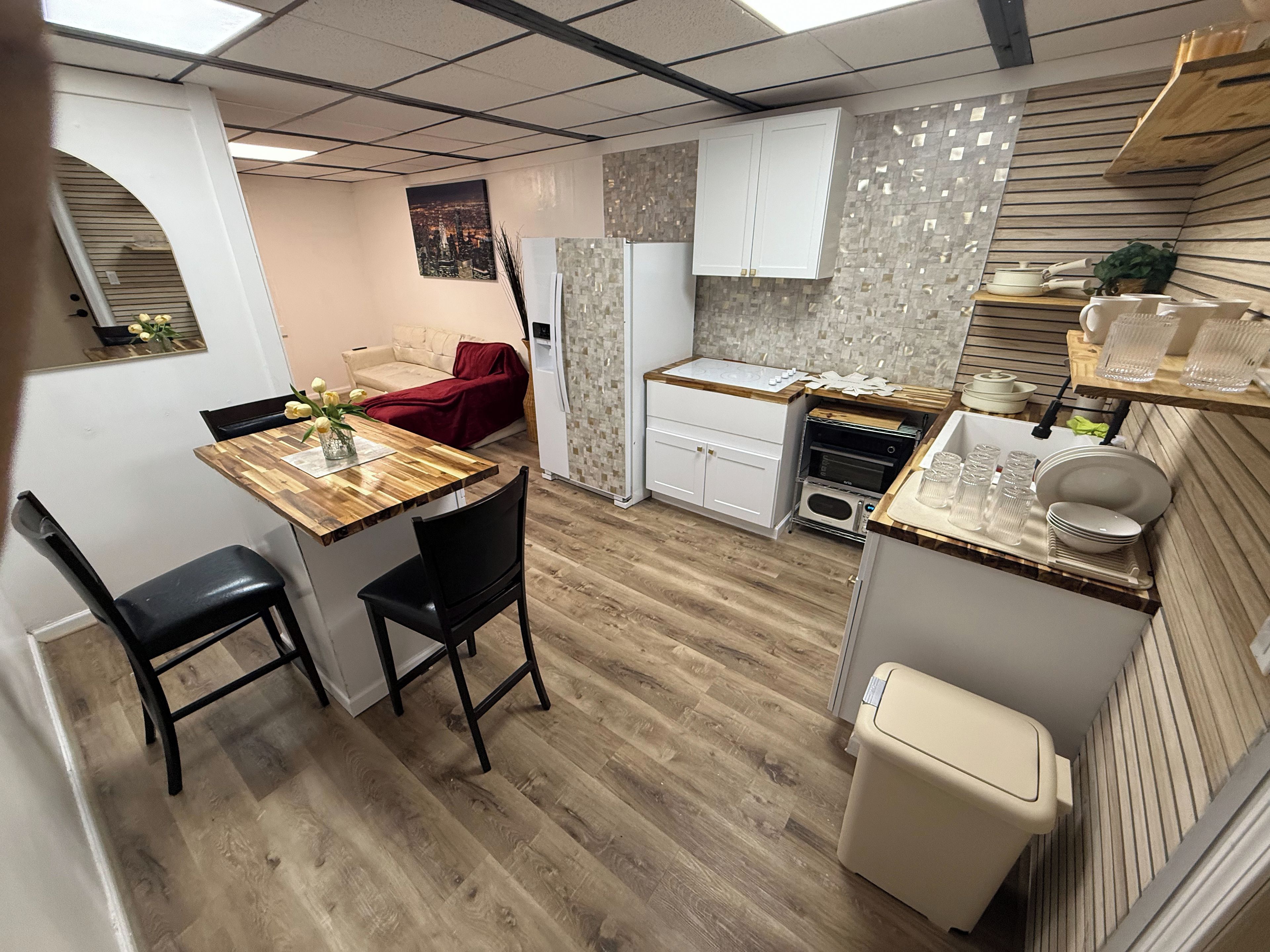 A compact kitchen with a dining area, a built-in oven, and a small seating area.