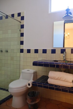 Een badkamer met toilet, wastafel en spiegel.