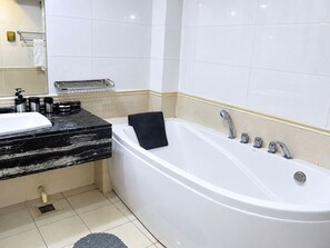 A bathroom with a white bathtub, a black towel, and a marble countertop. - HOTEL SAINT FRANCOIS DE PAULE  (brazzaville)
