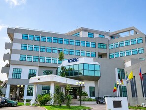 A multi-story building with a modern architectural design, featuring a prominent entrance with a glass facade and a sign that reads 'ACERAC'. - HOTEL SAINT FRANCOIS DE PAULE  (brazzaville)