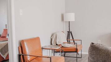 A modern living room with two leather armchairs, a small table, and a floor lamp.