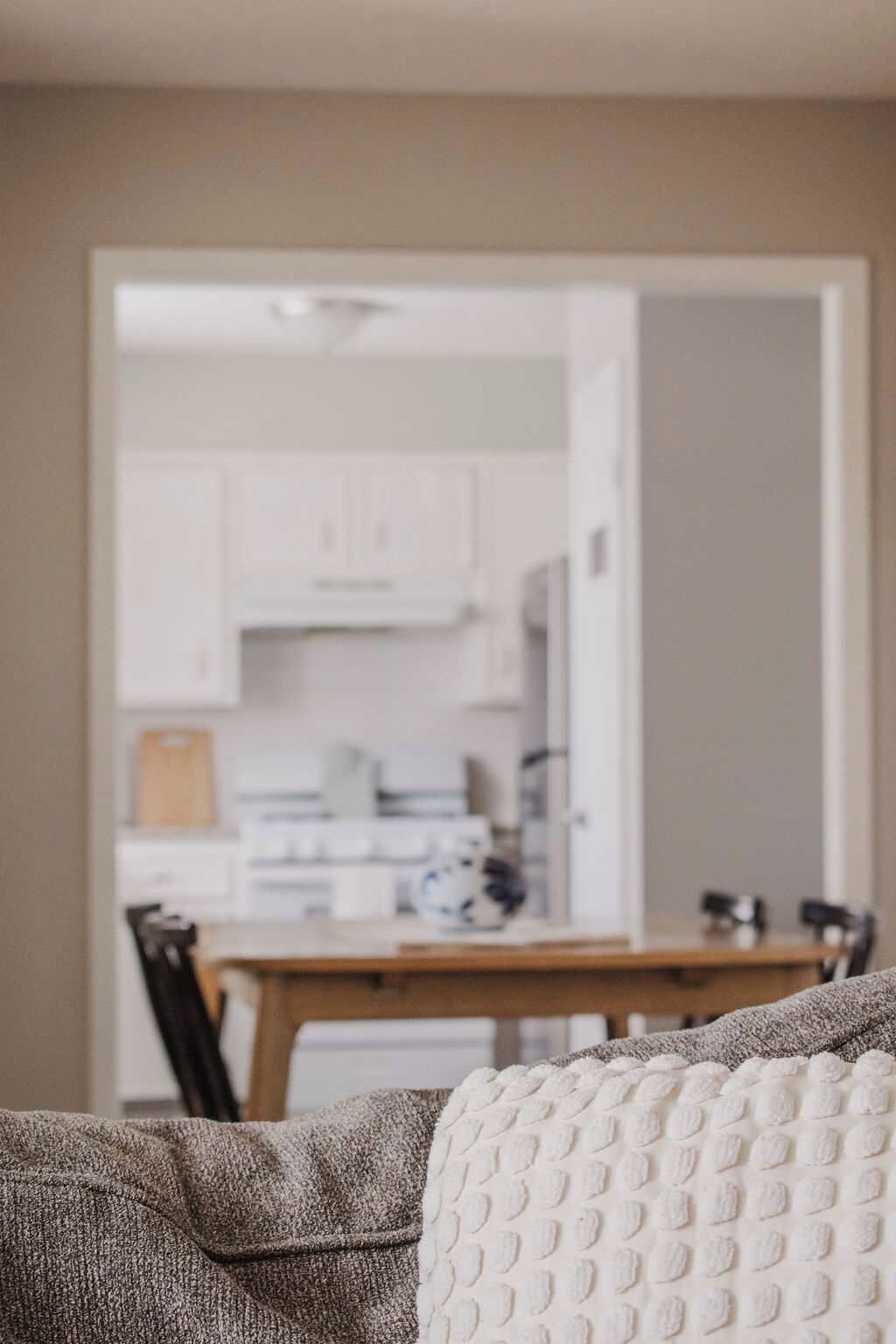 A living room with a view of a kitchen and dining area.