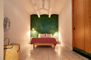 A bedroom with a bed, a ceiling fan, two bedside lamps, a woven basket, and a wooden door. - La Mina AC Beauty Great Location Comfort (Oaxaca)