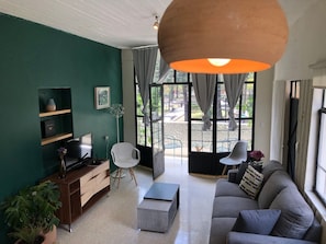 A living room with a sofa, a TV, a coffee table, and a potted plant. - La Mina AC Beauty Great Location Comfort (Oaxaca)