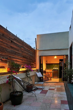 An outdoor patio area with a wooden fence, potted plants, and outdoor furniture. - La Mina AC Beauty Great Location Comfort (Oaxaca)
