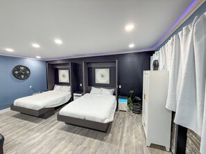 Ein modernes Schlafzimmer mit zwei Betten, einer Wanduhr und einem weißen Kleiderschrank.