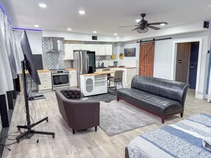 Eine moderne Küche mit weißen Schränken, einem Edelstahlkühlschrank und einer Holz Arbeitsplatte.