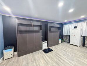 Ein Zimmer mit einem Kleiderschrank, einem kleinen Tisch und einer Topfpflanze.