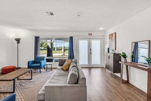 A modern living room with a sofa, armchairs, a coffee table, and a view of the outdoors. - Bayfront Villa 4 BR with Heated Pool 10 min walk to Beach (Hollywood)