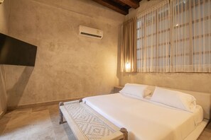 A bedroom with a bed, a wall-mounted air conditioner, and a window with curtains. - 5 Bedroom Luxury Villa in Old City (Cartagena de Indias)