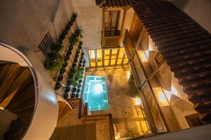 A courtyard with a glass-bottomed pool, wooden railings, and potted plants. - 5 Bedroom Luxury Villa in Old City (Cartagena de Indias)