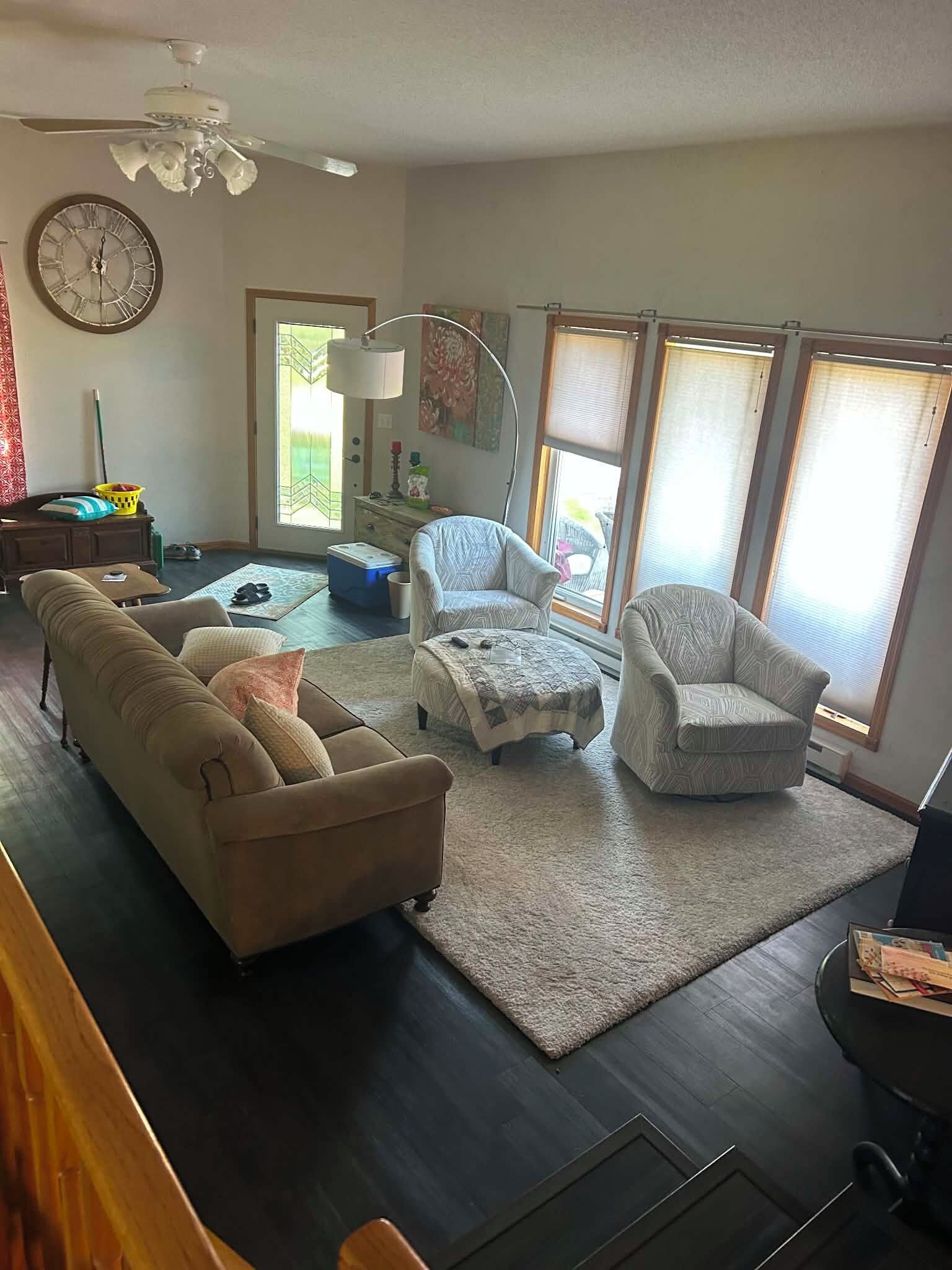 A living room with a sectional sofa, two armchairs, a coffee table, and a rug.
