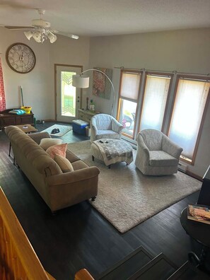 A living room with a sectional sofa, two armchairs, a coffee table, and a rug.