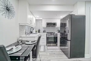 A modern kitchen with white cabinets, a stainless steel refrigerator, and a microwave. - LUXE By Marvalous
Luxury 2 bedroom 2 bathroom basement apartment in Brampton. (Brampton)