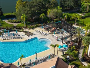 Ein Resort mit großem Pool, Liegestühlen und einem gepflegten Garten.