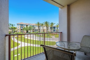 A balcony with a view of a residential area, a round table, and a chair. - Vista Cay 3BR, Spacious Condo, Sleeps 10 (Orlando)