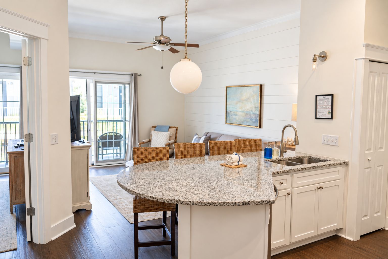 A kitchen with a central island, white cabinetry, a ceiling fan, and a view to the outside.