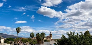 A clear sky with scattered clouds, palm trees, and a building with a dome. - La Fortaleza I Loft w AC Prime Historic Center Location (Oaxaca)