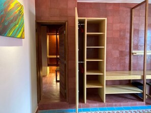 A room with a wooden wardrobe, a tiled floor, and a door leading to another room. - Rojo Stylish Apartment w AC and Premium Location in Historic Center (Oaxaca)