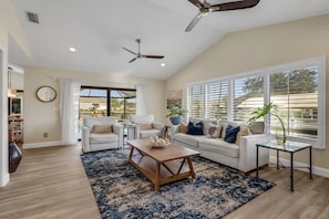 A spacious living room with a sofa set, a coffee table, and a side table with a vase. - The Capes Cozy Corner 1016 SW Cape Pool Home, Gulf Access (Cape Coral)