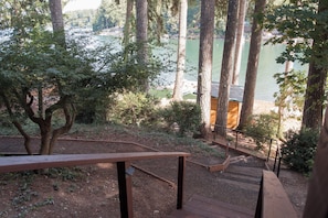 A wooden staircase leading to a viewing platform with a bench, surrounded by trees and overlooking a body of water. - WATERFRONT 4bd, 3.5ba Home w/ Private Dock, Hot Tub, Gas Fire Pit, 2 King Beds (Shelton)