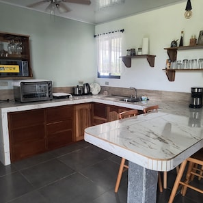 A kitchen with a built-in island, a microwave, a kettle, and a coffee maker. - New Listing (Provincia de Alajuela)