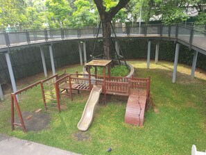 A playground with a slide and climbing structures, surrounded by a grassy area and a bridge. - 10 minutes to BTS bangna and river near true digital park and bitec 3 pools 2 gy (Krung Thep Maha Nakhon)