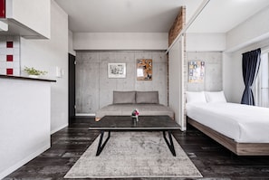 A modern bedroom with a sofa, a bed, a coffee table, and artwork on the walls. - J-STAR 802 (Sapporo)