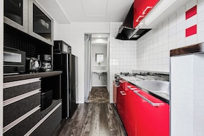 A modern kitchen with a black refrigerator, a red range hood, and a coffee maker. - J-STAR 802 (Sapporo)