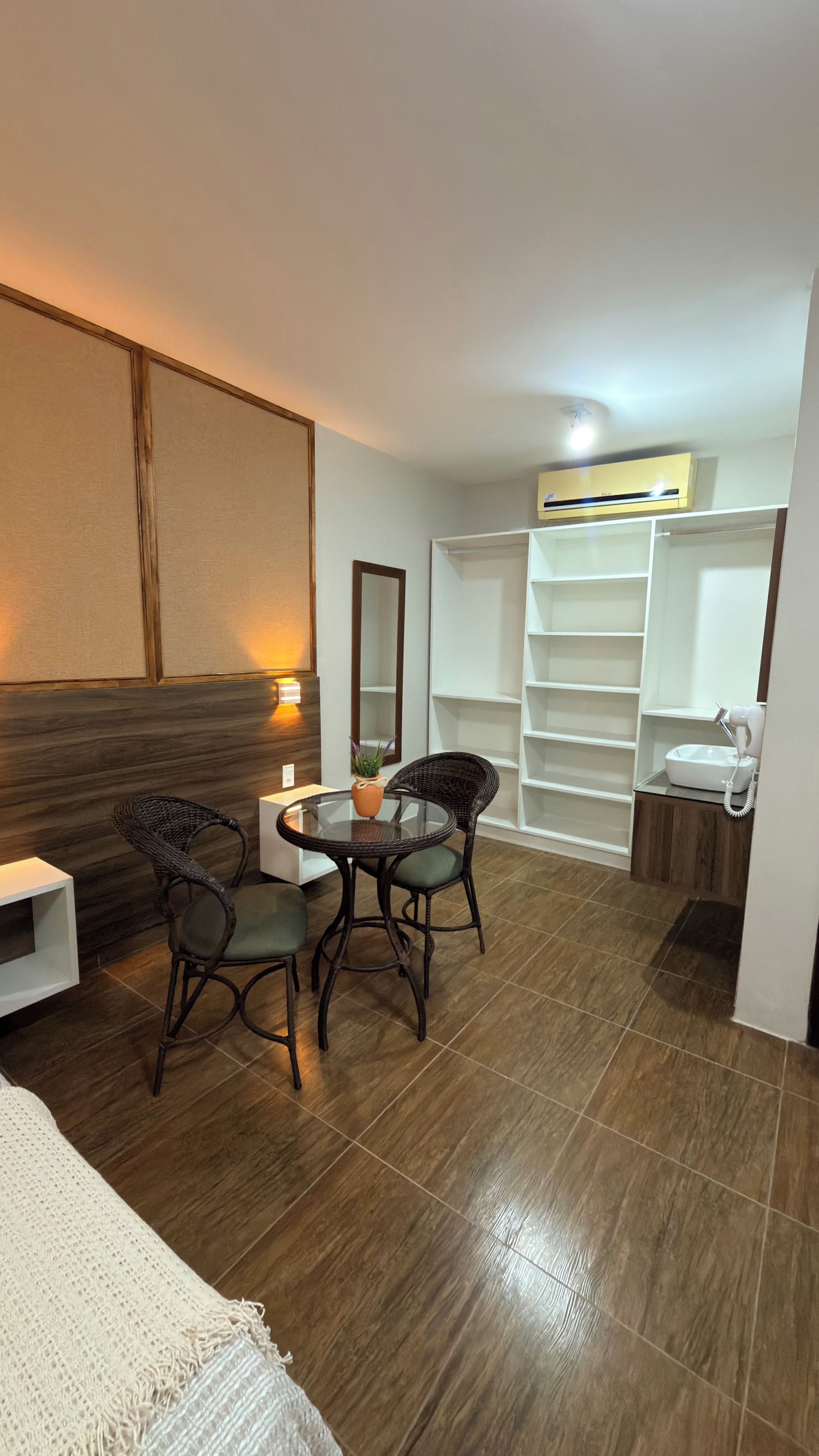 Une chambre d’hôtel comprenant un coin repas, un lit, une salle de bain et une grande fenêtre.