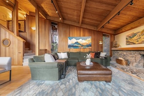 A cozy living room with a wooden ceiling, a staircase, and a painting of mountains. - Topaz Lake View at Dollar Point by Tahoe Getaways - Pet-Friendly 5BR w/ Private Hot Tub (Tahoe City)