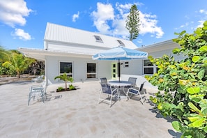 A house with a patio, outdoor seating, and a covered area. - White Heron | Beachfront Gulf Views, Access to Pool, Manasota Key (Englewood)