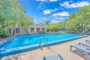 A rectangular swimming pool with a diving board, surrounded by lounge chairs and a covered seating area. - White Heron | Beachfront Gulf Views, Access to Pool, Manasota Key (Englewood)