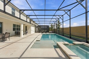 Una piscina exterior cubierta con zona de terraza, asientos y vistas al cielo.