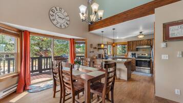 A spacious kitchen with wooden cabinets, a central island, and a dining area with a large table and chairs.
