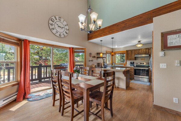 A spacious kitchen with wooden cabinets, a central island, and a dining area with a large table and chairs.