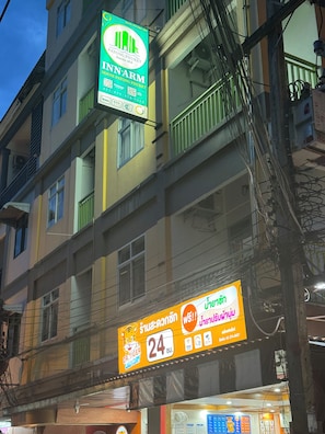 A multi-story building with a green sign for Innarm hotel and a yellow sign for Dr. Tiger Laundry. - Innarm House Patong  (Kathu District, Phuket, Thailand.)