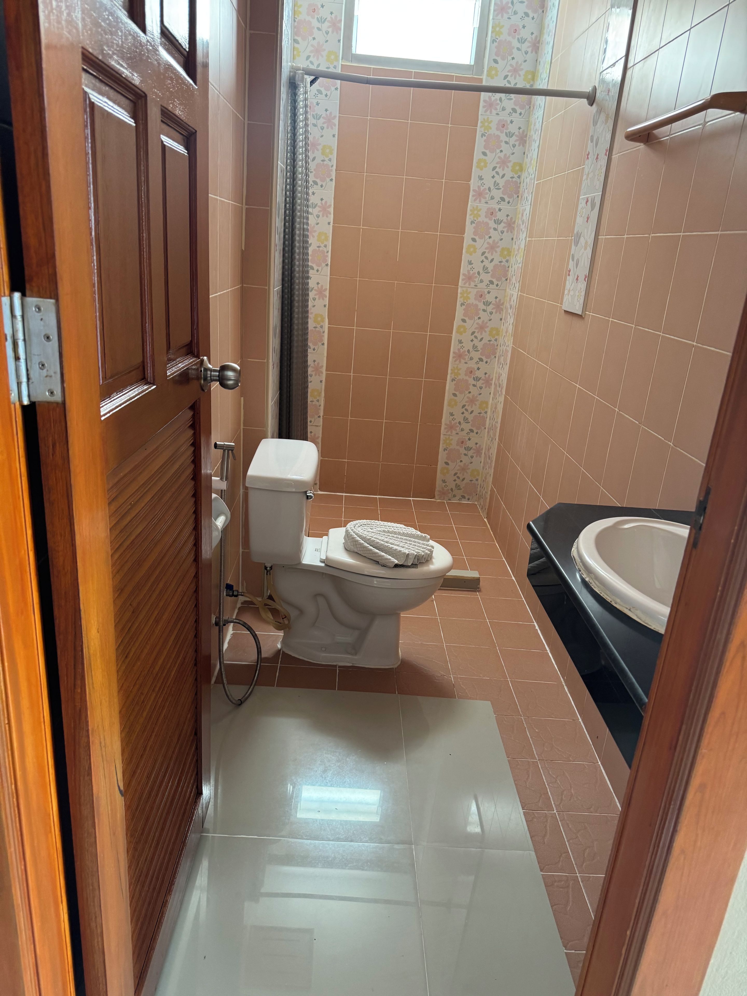 Een badkamer met toilet, douche en wastafel.