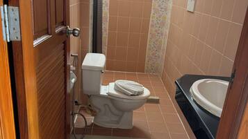 Een badkamer met toilet, douche en wastafel.