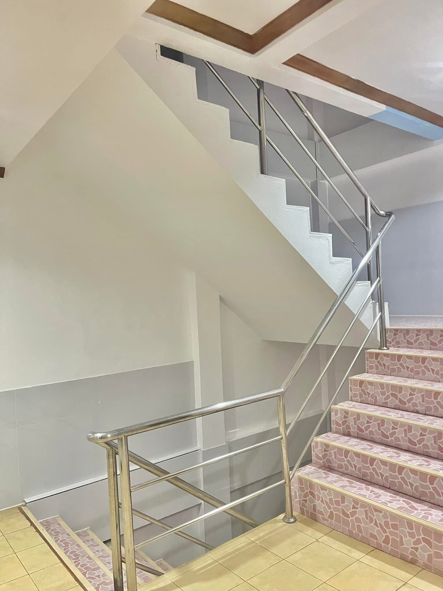 Uma escadaria moderna com corrimão de metal e degraus estampados.