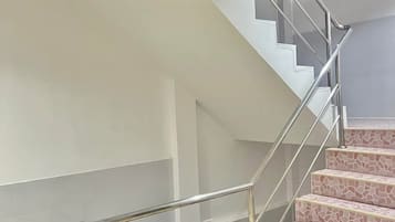 Uma escadaria moderna com corrimão de metal e degraus estampados.