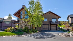 A two-story house with a stone facade, a balcony, and a well-maintained garden. - Trollhaugen Lodge | 4BR, Sleeps 10, Near Ski Base (Steamboat Springs)