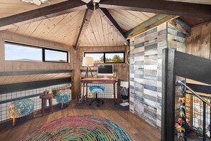 A room with a wooden ceiling, a desk with a computer, a colorful rug, and a view of the outdoors. - Welcome to "THE VOC" (Sedona)