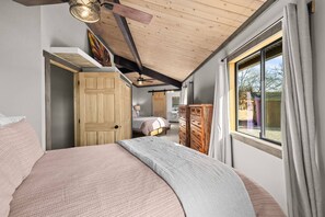 A bedroom with a large bed, a wooden wardrobe, a window with curtains, and a ceiling fan. - Welcome to "THE VOC" (Sedona)
