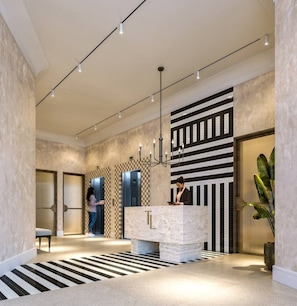 A modern hotel lobby with a reception desk, elevators, and a check-in counter. - The Landing Studio 610 Cape Town CBD (Cape Town)