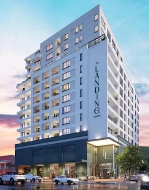 A multi-story hotel with a prominent 'LANDING' sign on the facade, featuring balconies on each floor, a ground-level entrance, and a parking area in front. - The Landing Studio 1003 Cape Town CBD (Cape Town)