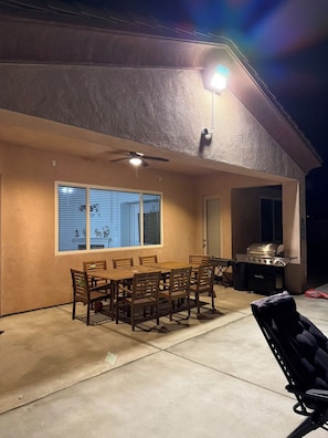 An outdoor patio with a dining table and chairs, a ceiling fan, and a barbecue grill. - Spacious 4-bedroom house in marvelous Desert Hot Springs with AC (Desert Hot Springs)