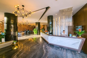 Eine Hotelhalle mit Rezeption, Billardtisch und Barbereich.