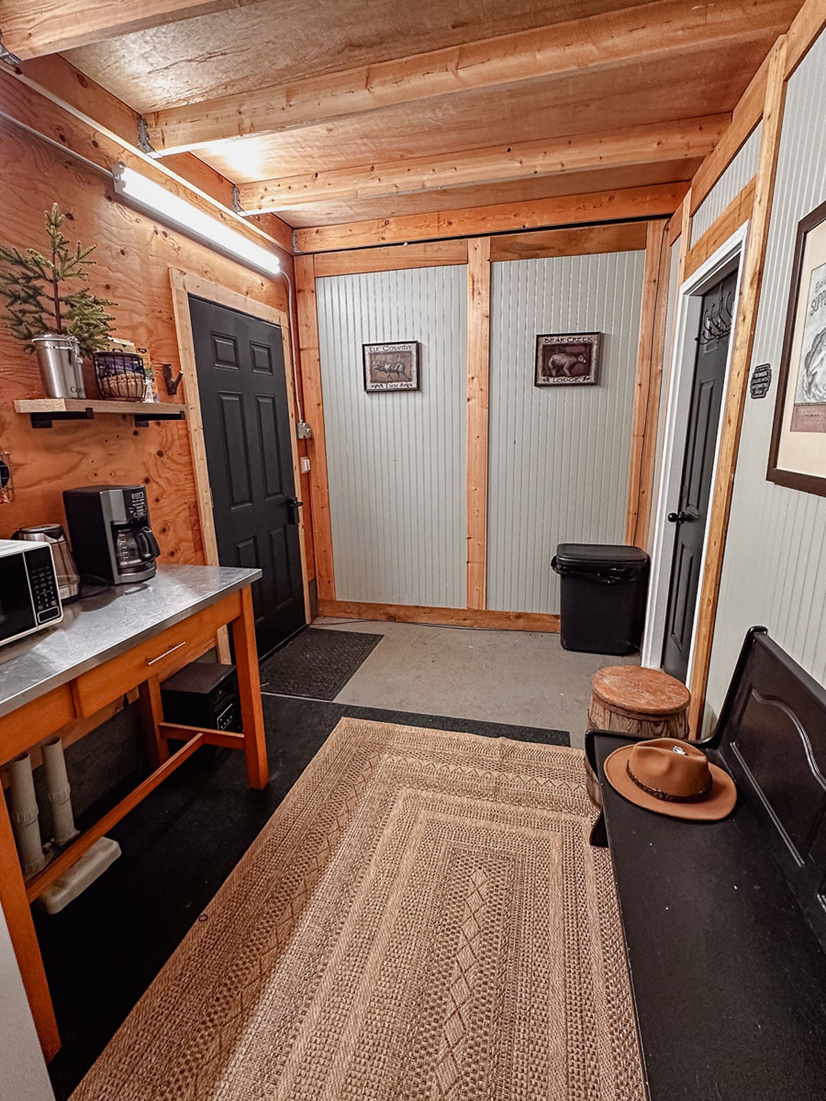 A compact kitchen with a wooden table, a coffee maker, and a trash bin.