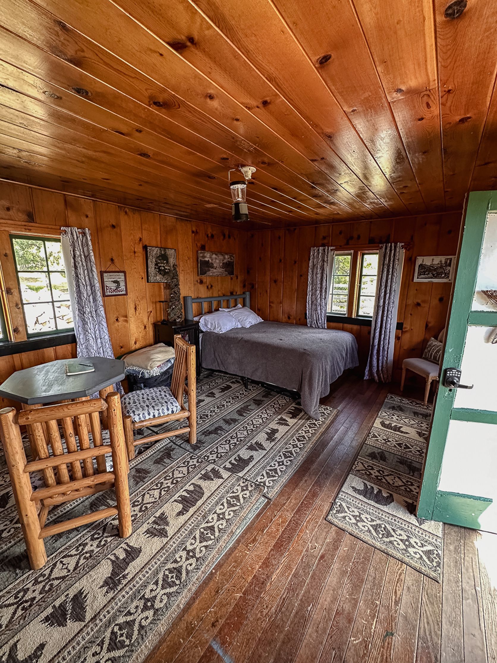 A cabin interior with a bed, a table, and a chair.